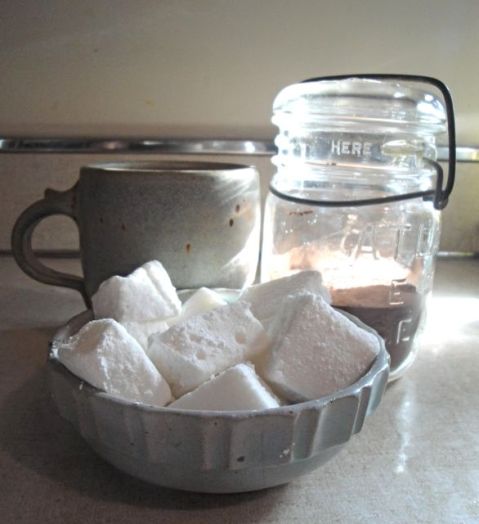 bowl with marshmallows glass jar with cocoa mix and mug